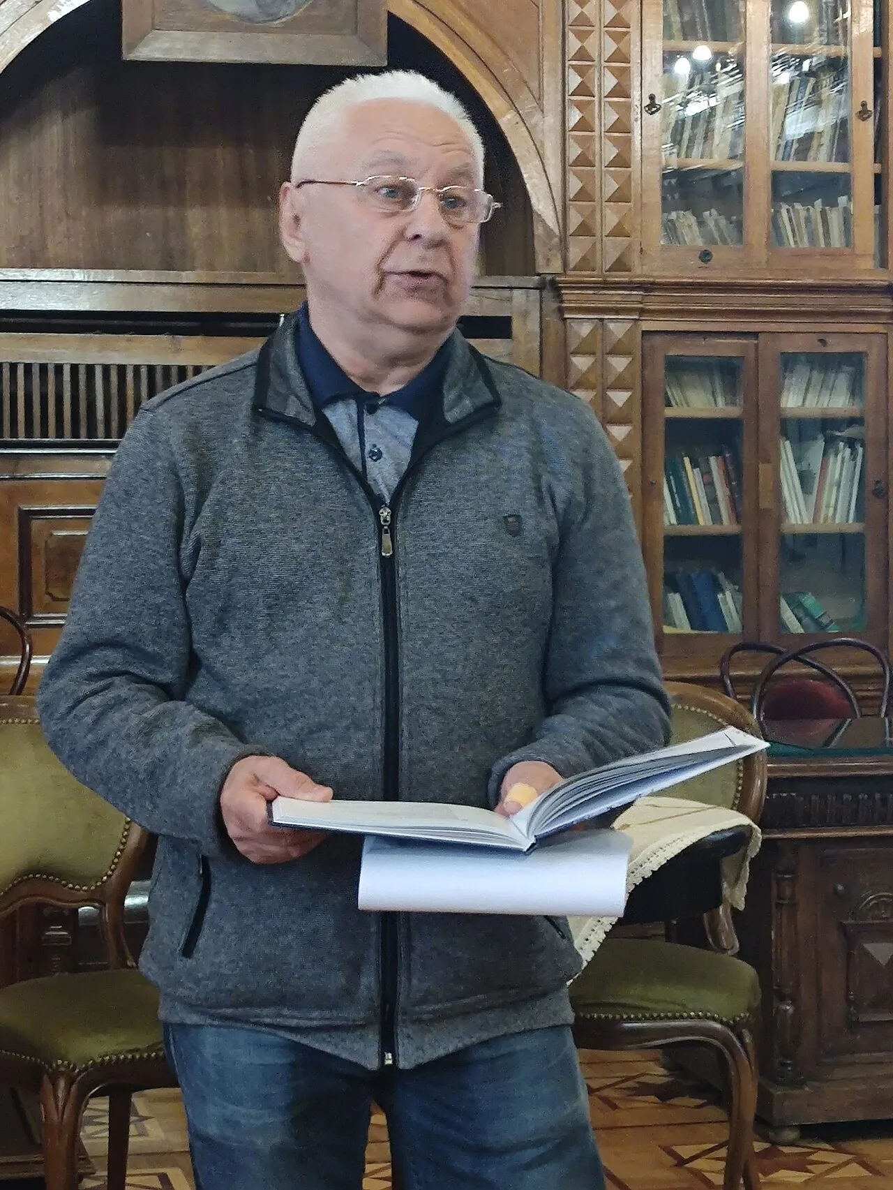 Станіслав Чернілевський тримає розгорнуту книжку